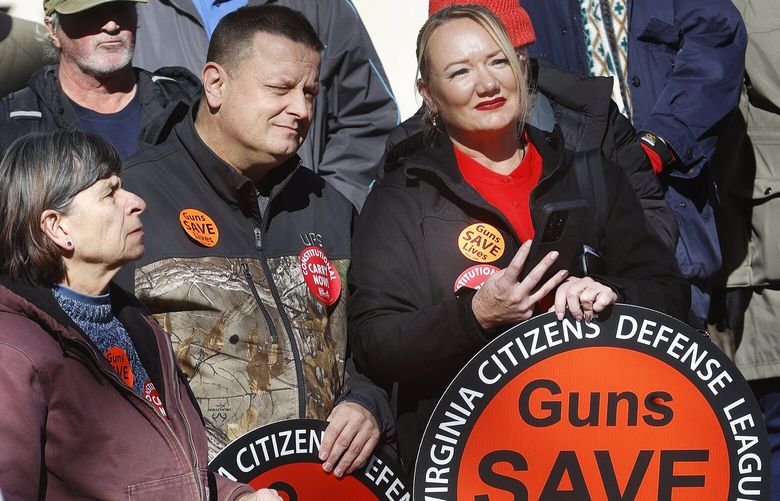 From left, Elly Hoinowski, of Giles County, and Jeff and Angela Akers of Christiansburg, listen to speakers during a gun rights rally at the Bell Tower in Capitol Square in Richmond, Va., on Lobby Day, Monday, Jan. 16, 2023. (Alexa Welch Edlund/Richmond Times-Dispatch via AP) VARIT109