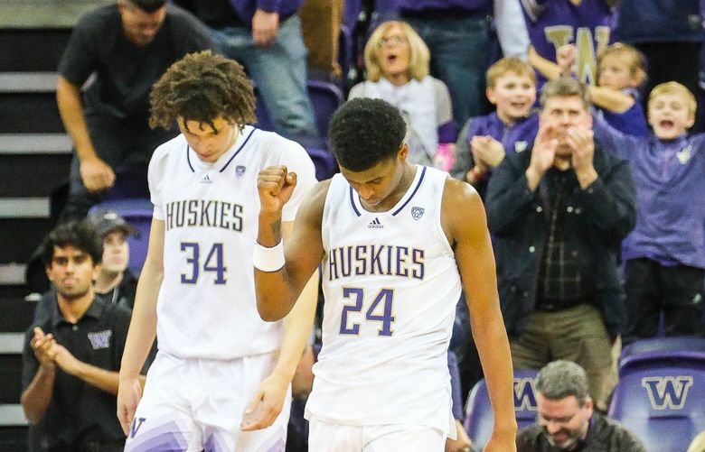 Noah Williams celebrates Washington’s 69-66 win over Arizona State in overtime with the Husky faithful at Alaska Airlines Arena Thursday. 222881
