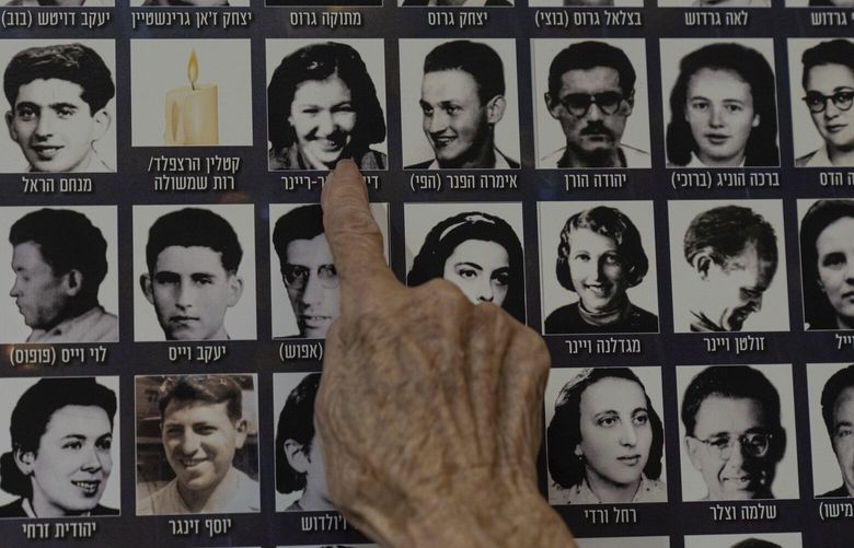 Dezi Heffner-Reiner points to her photo on a poster in memory of members of the Zionist youth movement underground in Hungary during the Holocaust at a ceremony awarding the Jewish Rescuers Citation, at Kibbutz HaZorea, northern Israel, Tuesday, Dec. 13, 2022. Just before Nazi Germany invaded Hungary in March 1944, Jewish youth leaders in the eastern European country jumped into action: they formed an underground network that in the coming months would rescue tens of thousands of fellow Jews from the gas chambers. (AP Photo/Tsafrir Abayov) XOB502 XOB502