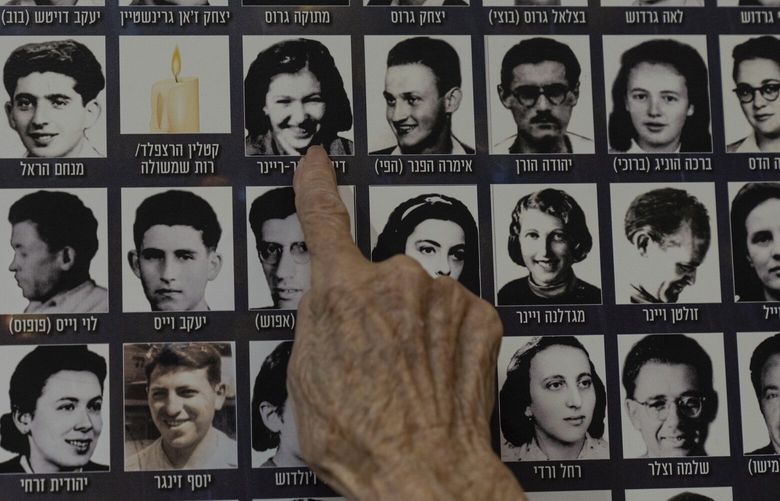 Dezi Heffner-Reiner points to her photo on a poster in memory of members of the Zionist youth movement underground in Hungary during the Holocaust at a ceremony awarding the Jewish Rescuers Citation, at Kibbutz HaZorea, northern Israel, Tuesday, Dec. 13, 2022. Just before Nazi Germany invaded Hungary in March 1944, Jewish youth leaders in the eastern European country jumped into action: they formed an underground network that in the coming months would rescue tens of thousands of fellow Jews from the gas chambers. (AP Photo/Tsafrir Abayov) XOB502 XOB502