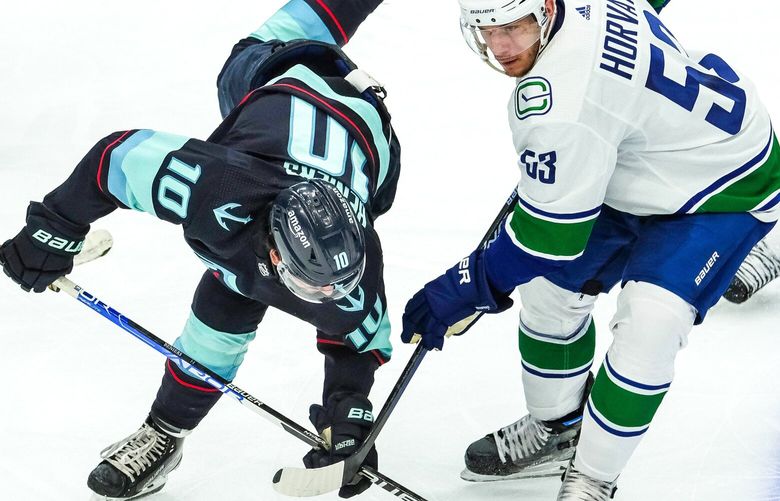 Seattle’s Matty Beniers stays upright after bumping with Vancouver’s Bo Horvat in the second peroiod. 222841 222841