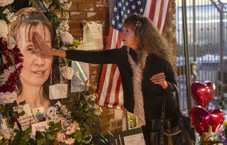 Adele Castro, 68, who said she knew all the victims, touches the photo of Mymy Nhan at a memorial outside Star Dance Studio in Monterey Park, Calif., Thursday, Jan. 26, 2023. “So painful, so painful,” said Castro. (AP Photo/Jae C. Hong) CAJH111