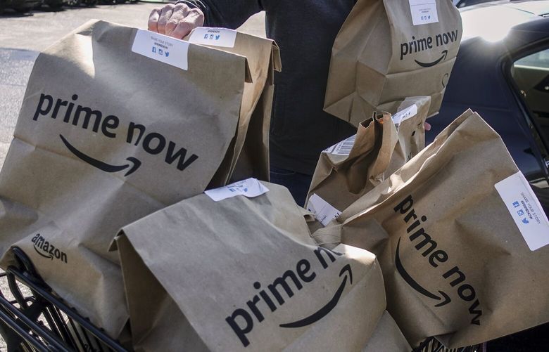 FILE – In this Feb. 8, 2018, file photo, Amazon Prime Now bags full of groceries are loaded for delivery by a part-time worker outside a Whole Foods store in Cincinnati. Amazon and Whole Foods are rolling out their grocery delivery service in several locations Wednesday, Sept. 26, while expanding it in other areas. (AP Photo/John Minchillo, File) NYAG302