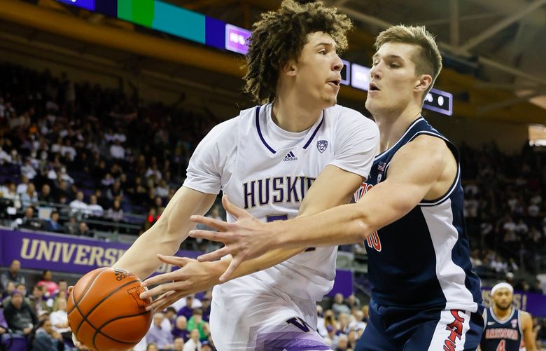 Washington Huskies center Braxton Meah passes along the baseline through the defense of Arizona Wildcats forward Azuolas Tubelis during the first half. 222842