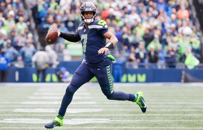 Seattle Seahawks quarterback Geno Smith looks to pass after scrambling out of the pocket during the first quarter. 222737