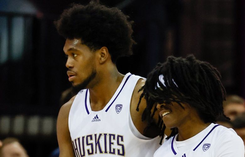 Washington Huskies forward Keion Brooks, left, and guard Keyon Menifield walk back to the bench as Arizona increases their lead during the second half. 222883