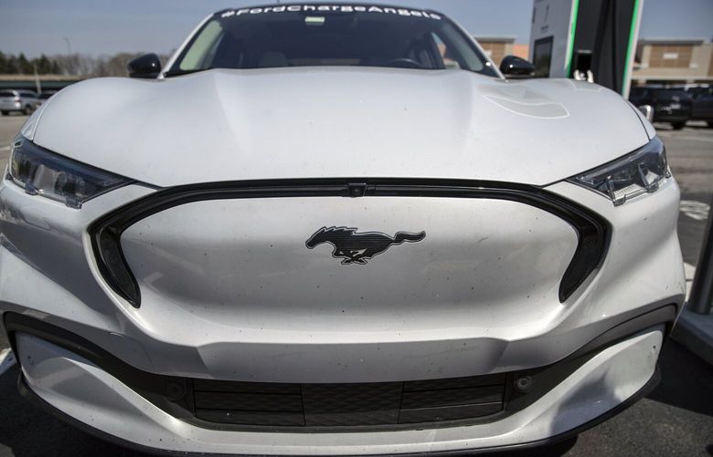 FILE – A Ford Mustang Mach-E at a charging station in Waterford, Mich., on April 14, 2022. Ford is cutting the price of its popular Mustang Mach-E sport-utility vehicle weeks after Tesla cut prices for its cars. (Victor J. Blue/The New York Times) 