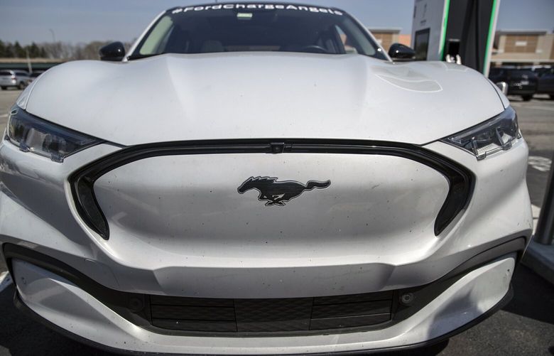 FILE – A Ford Mustang Mach-E at a charging station in Waterford, Mich., on April 14, 2022. Ford is cutting the price of its popular Mustang Mach-E sport-utility vehicle weeks after Tesla cut prices for its cars. (Victor J. Blue/The New York Times)