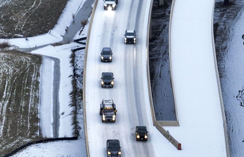 An icy mix covers Highway 114 on Monday, Jan. 30, 2023, in Roanoke, Texas. Dallas and other parts of North Texas are under a winter storm warning through Wednesday. (Lola Gomez/The Dallas Morning News via AP) TXDAM844 TXDAM844