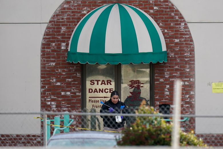An investigator carries markers outside Star Dance Studio in Monterey Park, Calif., Sunday, Jan. 22, 2023. A mass shooting took place at the dance club following a Lunar New Year celebration, setting off a manhunt for the suspect in the fifth mass killing in the U.S. this month. (AP Photo/Jae C. Hong)