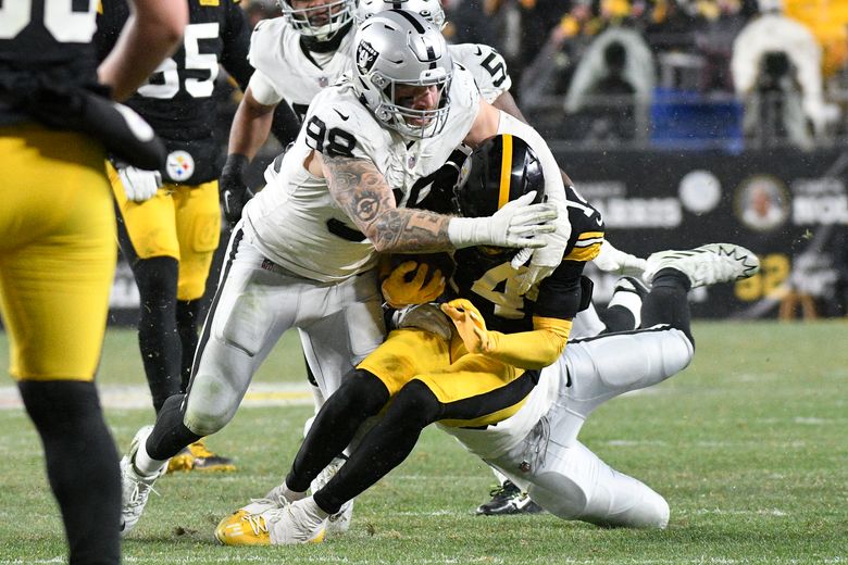 Raiders defensive end Maxx Crosby (98) talks with teammates during