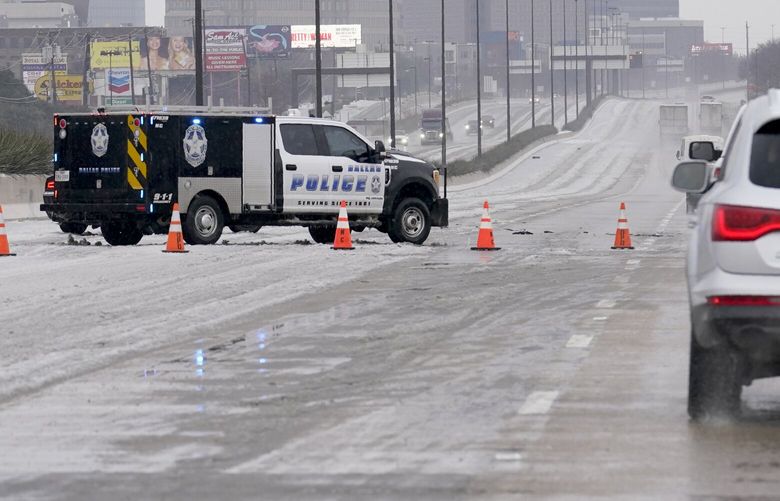 A City of Dallas emergency vehicle blocks lanes of US 75 during icy and slushy road conditions, Wednesday, Feb. 1, 2023, in Dallas. (AP Photo/Tony Gutierrez) TXTG106 TXTG106