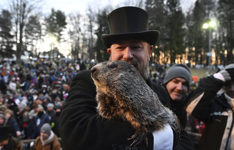 Groundhog Club handler A.J. Dereume holds Punxsutawney Phil, the weather prognosticating groundhog, during the 136th celebration of Groundhog Day on Gobbler’s Knob in Punxsutawney, Pa., Wednesday, Feb. 2, 2022. Phil’s handlers said that the groundhog has forecast six more weeks of winter. (AP Photo/Barry Reeger)