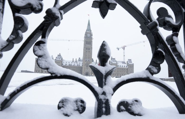 Snow covers a fence surrounding Parliament Hill, Friday, Jan. 20, 2023 in Ottawa. (Adrian Wyld /The Canadian Press via AP) ajw107 ajw107