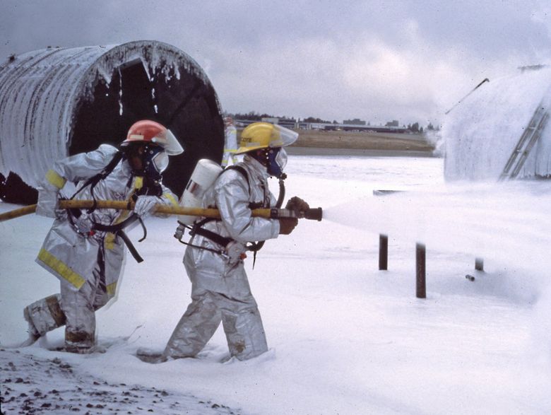 In this photo of a Sea-Tac training exercise in the 1980s or early 1990s, crews use PFAS firefighting foam. They wear self-contained breathing apparatus in this photo, but firefighters have said that they often did not wear it in such training back then. (Courtesy of the Port of Seattle Fire Department)