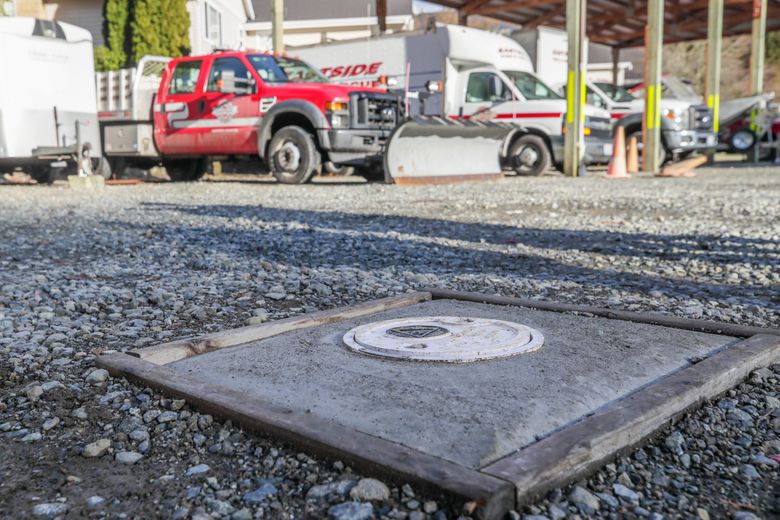 A round cap marks the top of a monitoring well where groundwater has been contaminated at Eastside Fire and Rescue in Issaquah. The state Ecology Department is testing techniques at this site to curb the spread of PFAS water pollution. (Kevin Clark / The Seattle Times)