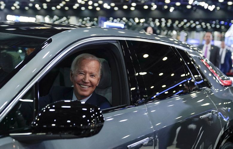 FILE – President Joe Biden drives a Cadillac Lyriq through the showroom during a tour at the Detroit Auto Show, Sept. 14, 2022, in Detroit.  Ratcheting  up his criticism of the Biden administration, Democratic Sen. Joe Manchin introduced legislation Wednesday to delay new tax credits for electric vehicles, a key feature of President Joe Biden’s landmark climate law. Manchin said guidelines issued by the Treasury Department allow manufacturers in Europe and other countries to bypass requirements that significant portions of EV batteries must be produced in North America.  (AP Photo/Evan Vucci, File) WX102 WX102