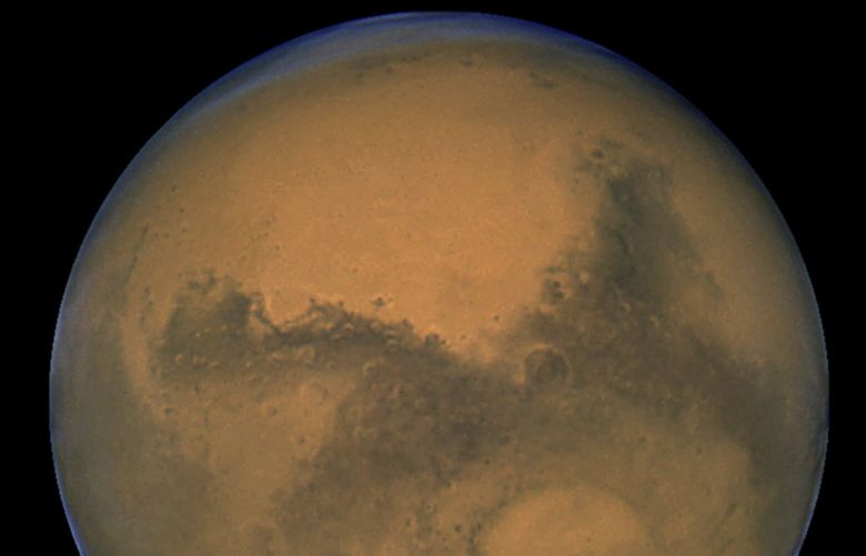 FILE – This Aug. 26, 2003, image made available by NASA shows Mars as it lines up with the Sun and the Earth. Photographed by the Hubble Space Telescope, it was about 55.8 million kilometers (34.6 million miles) from Earth.  On Friday, May 20, 2022,  The Associated Press reported on stories circulating online incorrectly claiming NASAâ€™s Mars rover has captured images of a doorway cut into a mountainside of the red planet, suggesting the presence of extraterrestrial life.  (NASA/J. Bell – Cornell U./M. Wolff – SSI via AP, File) NYNR101