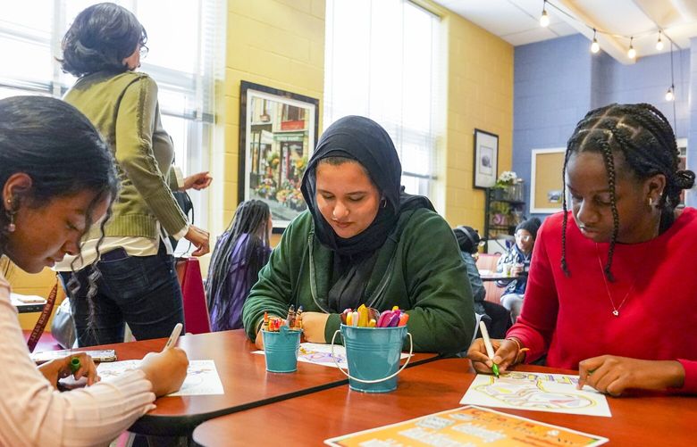 From left: Mistere Moges, Hanan Jazouli and Aretha Were talk and color during an event aimed at helping students ease back into full-time in-person learning at Paint Branch High School in Burtonsville, Md., on Wednesday.