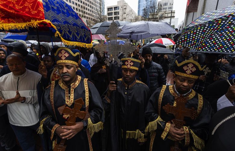 Seattle area priests of the area’s many Ethiopian Orthodox Churches, as well as other church officials are joined with demonstrators at Westlake Park to protest the Ethiopian government, accusing it of constant attacks and trying to split the church by not recognizing only Patriarch Abuna Mathias as its head of leadership, or synod, Sunday, Feb. 5, 2023, in downtown Seattle. Rain didn’t stop large numbers of congregants of the area’s many Ethiopian Orthodox Churches from showing up to listen to speakers, and to pray, chant and sing before marching to the Space Needle.