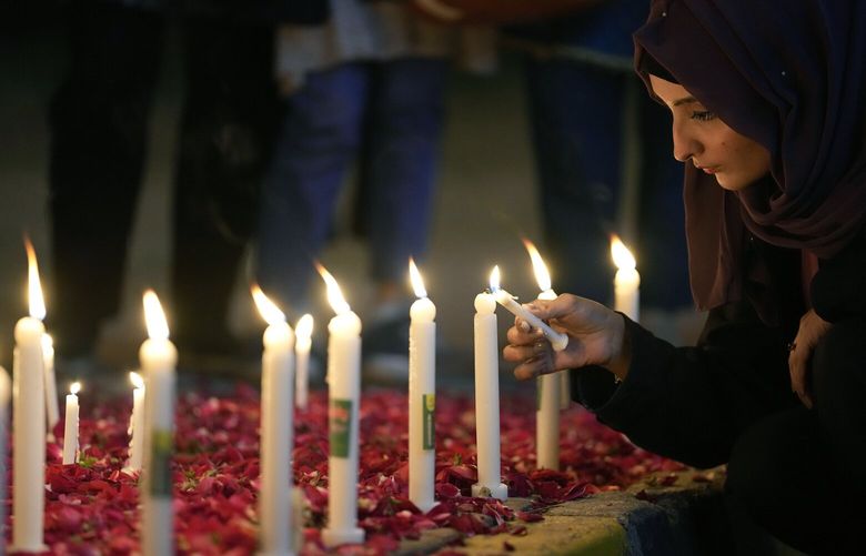A woman light candles during a candle light vigil for the victims of earthquake in Syria and Turkey, in Islamabad, Pakistan, Monday, Feb. 6, 2023. A powerful 7.8 magnitude earthquake has rocked wide swaths of Turkey and Syria. It toppled hundreds of buildings and killed more than 1,900 people. Hundreds are still believed to be trapped under rubble, and the toll is expected to rise as rescue workers search mounds of wreckage in cities and towns across the area. (AP Photo/Anjum Naveed) ANJ103 ANJ103