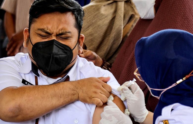 A man reacts as health official delivers the fourth dose of COVID-19 coronavirus vaccine in Jakarta on January 25, 2023. (Azwar Ipank/AFP via Getty Images/TNS)