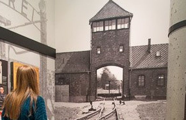A student absorbs the horror of train tracks leading into the Auschwitz-Birkenau concentration and death camp as part of the permanent exhibit at the Holocaust Center for Humanity.