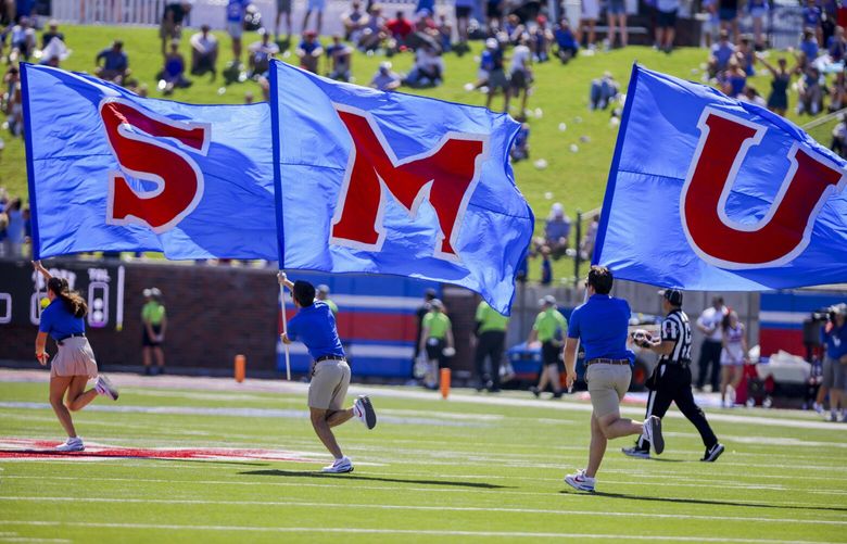 SMU flags are run across the field during a time out in the second half of an NCAA college game against TCU on Saturday, Sept. 24, 2022, in Dallas, Texas. (AP Photo/Gareth Patterson)