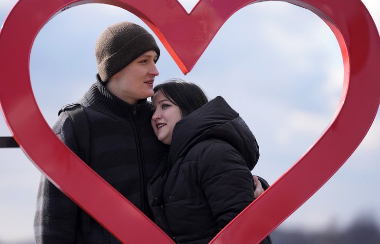 Mariia Vyhivska, from Ukraine, left, and Iurii Kurochkin, from Russia, pose with a heart-shaped sign on the banks of the Ada Ciganlija Lake, in Belgrade, Serbia, Sunday, Feb. 5, 2023. Vyhivska and Kurochkin fell in love before Russia invaded Ukraine, while playing an online video game. To get together, they had to leave their homes and defy hatred generated by war. An estimated 200,000 Russians and some 20,000 Ukrainians have come to Serbia in the past year. (AP Photo/Darko Vojinovic) XDMV506 XDMV506