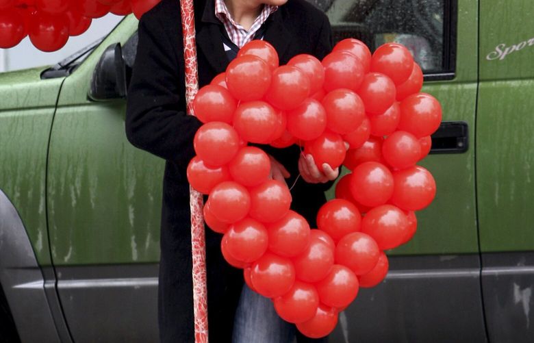 red balloons shaped into a heart on Valentine’s  Day in  2012. (AP Photo/Selcan Hacaoglu) 