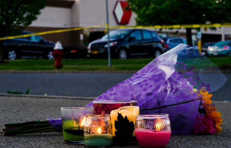 FILE – Flowers and candles lay outside the scene of a shooting at a supermarket, in Buffalo, N.Y., Sunday, May 15, 2022.  Payton Gendron is set to be sentenced to life in prison Wednesday, Feb. 15, 2023 for killing 10 Black people at a Buffalo supermarket in an attack fueled by racist conspiracy theories he encountered online. (AP Photo/Matt Rourke, File) NY130 NY130