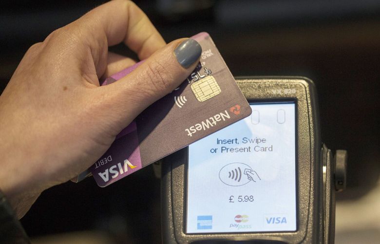 A customer makes a  payment using a card with a chip in 2015. ( Simon Dawson/Bloomberg)