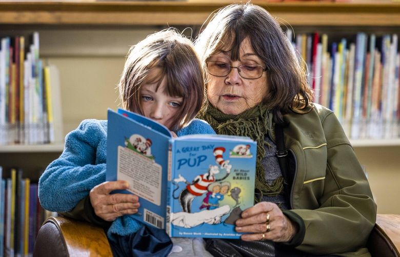 Maureen Doyle and granddaughter Penny, 7, read a book together the Seattle Public Library, Columbia branch on Wednesday, Feb. 15, 2023. Doyle says that every Wednesday they come to read together.