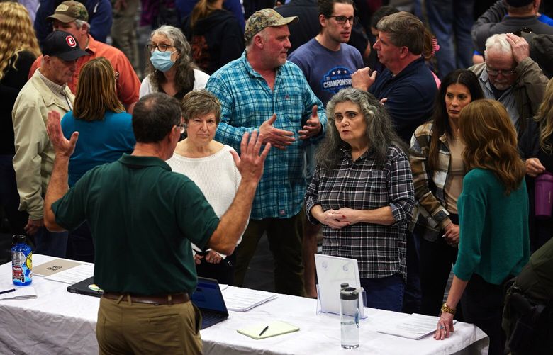 Local residents speak with an official from the Ohio Department of Natural Resources during a meeting in East Palestine, Ohio, on Wednesday night, Feb. 15, 2023. Hundreds of residents gathered in a school gym to demand answers about the ongoing fallout from a derailed train carrying hazardous chemicals, transforming what had been billed as an informational meeting into a heated town hall where officials with the railroad company didn’t even show up. (Brian Kaiser/The New York Times) XNYT202 XNYT202