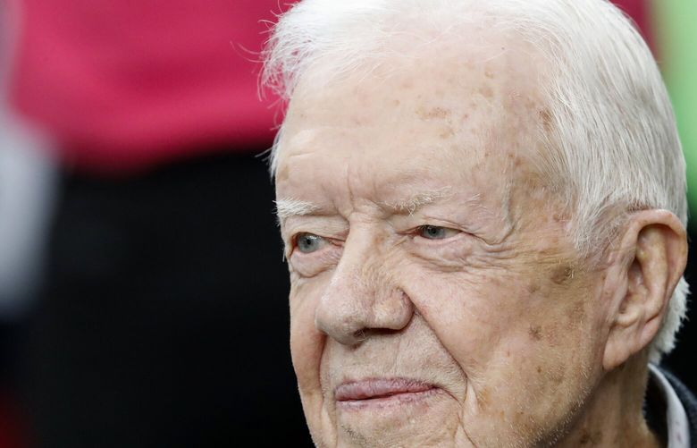 FILE – Former President Jimmy Carter sits on the Atlanta Falcons bench before the first half of an NFL football game between the Atlanta Falcons and the San Diego Chargers, Sunday, Oct. 23, 2016, in Atlanta. Carter, at age 98 the longest-lived American president, had a recent series of short hospital stays. The Carter Center said in a statement Saturday, Feb. 19, 2023, that the 39th president has now “decided to spend his remaining time at home with his family and receive hospice care instead of additional medical intervention.” (AP Photo/John Bazemore, File) WX102 WX102