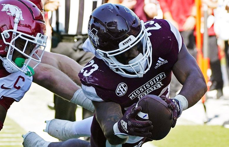 Mississippi State running back Dillon Johnson (23) dives into the end zone past Arkansas defenders for a 30-yard touchdown run during the second half of an NCAA college football game in Starkville, Miss., Saturday, Oct. 8, 2022. Mississippi State won 40-17. (AP Photo/Rogelio V. Solis)