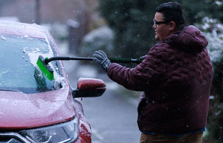 Michael Toughill brushes snow off a vehicle in West Seattle Wednesday, Feb. 22, 2023. 
 223144