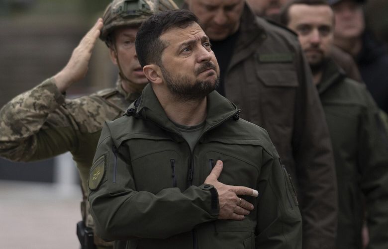 FILE – Ukrainian President Volodymyr Zelenskyy takes part in a national flag-raising ceremony in Izium, Ukraine, Wednesday, Sept. 14, 2022.  A year ago, with Russian forces bearing down on Ukraine’s capital, Western leaders feared for the life of President Volodymyr Zelenskyy and the U.S. offered him an escape route. Zelenskyy declined, declaring his intent to stay and defend Ukraine’s independence.  (AP Photo/Leo Correa, File) XVZ116 XVZ116