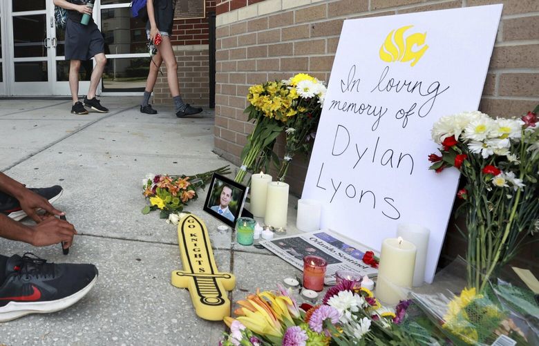 A person sits in front of the pop-up memorial for slain Spectrum News 13 journalist Dylan Lyons at the University of Central Florida Nicholson School of Communications in Orlando, Fla., Thursday, Feb. 23, 2023. Lyons, a graduate of UCF, was shot and killed while covering a homicide in Orlando on Wednesday. (Joe Burbank /Orlando Sentinel via AP) FLORL102 FLORL102