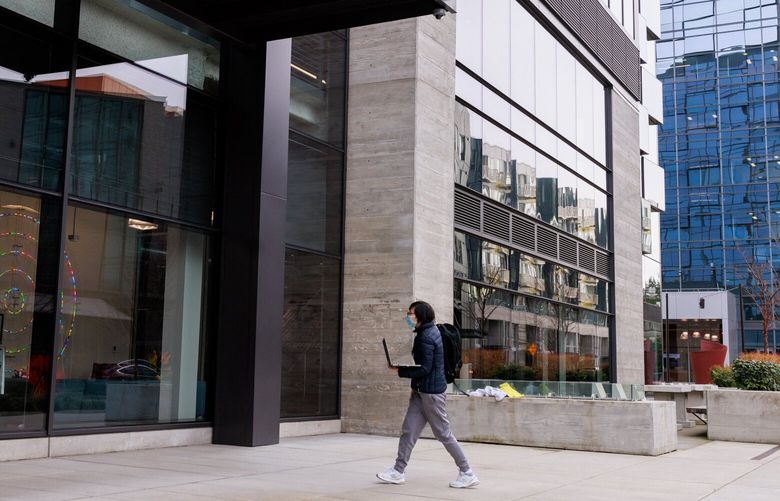 A pedestrian with a laptop enters Meta offices in Bellevue, Wash. Thursday, Feb. 23, 2023.  223151