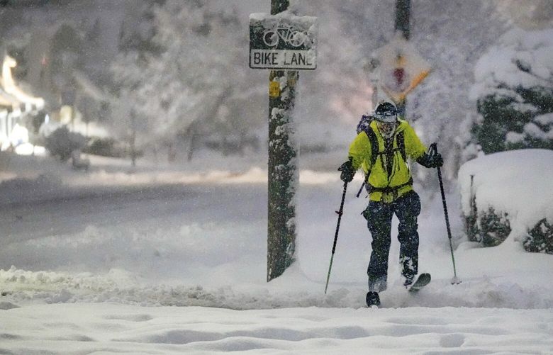 Kai Benedict commutes to his job at the VA Hospital by skis following a snow storm that blanketed the Salt Lake Valley with snow on Wednesday, Feb. 22, 2023 in Salt Lake City, Utah.  Brutal winter weather hammered the northern U.S. Wednesday with “whiteout” snow, dangerous wind gusts and bitter cold, shutting down roadways, closing schools and businesses and prompting dire warnings for people to stay home.  (Francisco Kjolseth /The Salt Lake Tribune via AP) UTSAC105 UTSAC105