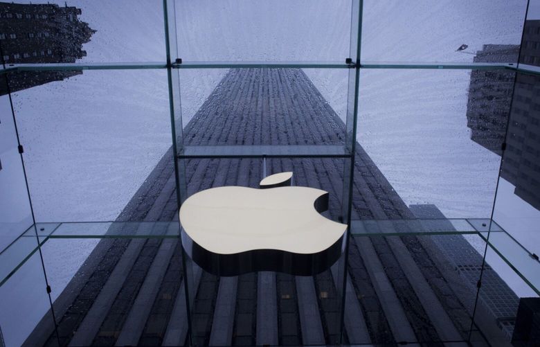The Apple Inc. logo is seen at the entrance to a store as it rains in New York, U.S., on Thursday, Sept. 10, 2015. Photographer: John Taggart/Bloomberg