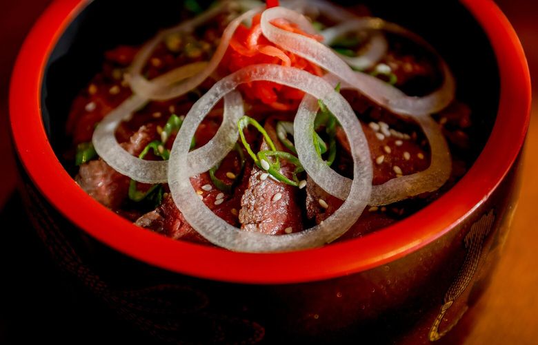 A halo of onion rounds highlight the Wagyu don at Itsumono. The Wagyu don features Wagyu hanger steak, Yoshinoya beef fat sauce, onions and ginger on a bed of rice. 223141