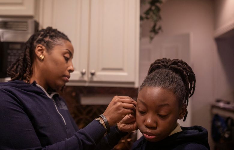 J. Marie Jones helps her daughter, Kaiya, get ready before school at their home in Roosevelt, N.Y., on Jan. 31, 2023. Jones is one of the many single mothers who found that quitting her job had a profound affect on her family life. (Kirsten Luce/The New York Times)