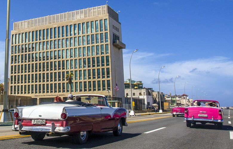 FILE – In this Oct. 3, 2017, file photo, tourists ride classic convertible cars on the Malecon beside the United States Embassy in Havana, Cuba. The Biden administration faces increasing pressure to respond to a sharply growing number of reported injuries suffered by diplomats, intelligence officers and military personnel that some suspect are caused by devices that emit waves of energy that disrupt brain function. The problem has been labeled the “Havana Syndrome,” because the first cases affected personnel in 2016 at the U.S. Embassy in Cuba. (AP Photo/Desmond Boylan, File) WX101