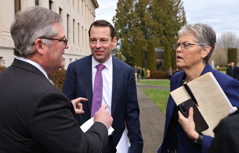 Rep. JT Wilcox, R-Yelm (House Republican Leader), left, Sen. Sen. Andy Billig, D-Spokane (Senate Democratic Leader), and House Speaker Laurie Jinkins, D-Tacoma, all members of the Legislative Caucus leaders pane speak outside during a false fire alarm in the John A. Cherberg building at the Capitol in Olympia on Thursday, January 5,  2022.