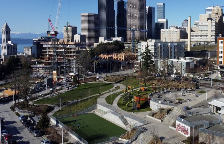 With downtown Seattle in the background, Yesler Terrace Park and community center, at right, is seen from the air Sunday, Jan. 29, 2023. More market-rate housing has developed around Yesler Terrace, which is Washington State’s first public housing development, opening in the 1940s; and at the time it became the first racially integrated public housing development in the United States.