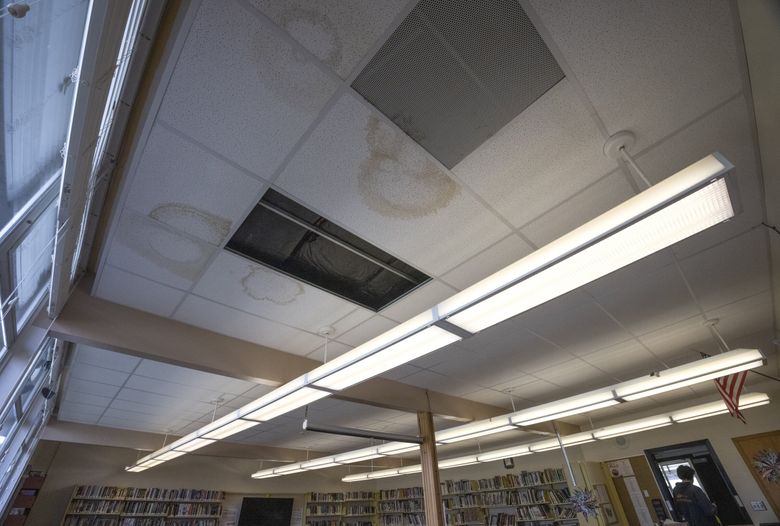 Leaks have stained and left a hole in the ceiling of the library at  Wahkiakum High School. “It’s so refreshing,” joked Brookylnn Luthi, a senior, about the leaks. “Like a shower.”  (Ellen M. Banner / The Seattle Times)