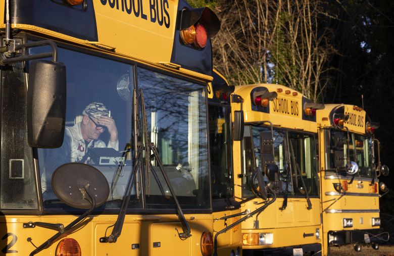 Calvin Grasseth, the  transportation supervisor of the Wahkiakum School District, finishes the end of the day in his bus. Grasseth wears a number of hats at the district. (Ellen M. Banner / The Seattle Times)