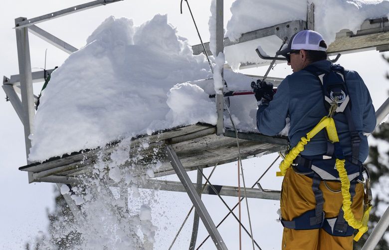 Andrew Schwartz, a scientist at the University of California at Berkeley Central Sierra Snow Laboratory, clears snow from scientific equipment on a lab tower in Soda Springs, Calif., on March 02, 2023. MUST CREDIT: Photo for The Washington Post by Josh Edelson.